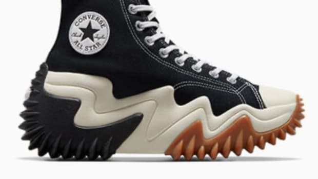 Side view of a black and tan Converse sneaker.